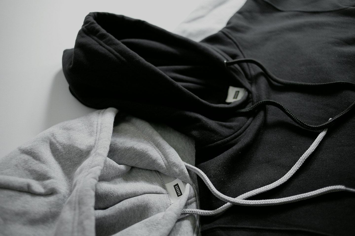 A black and grey hooded sweatshirt folded on a surface.
