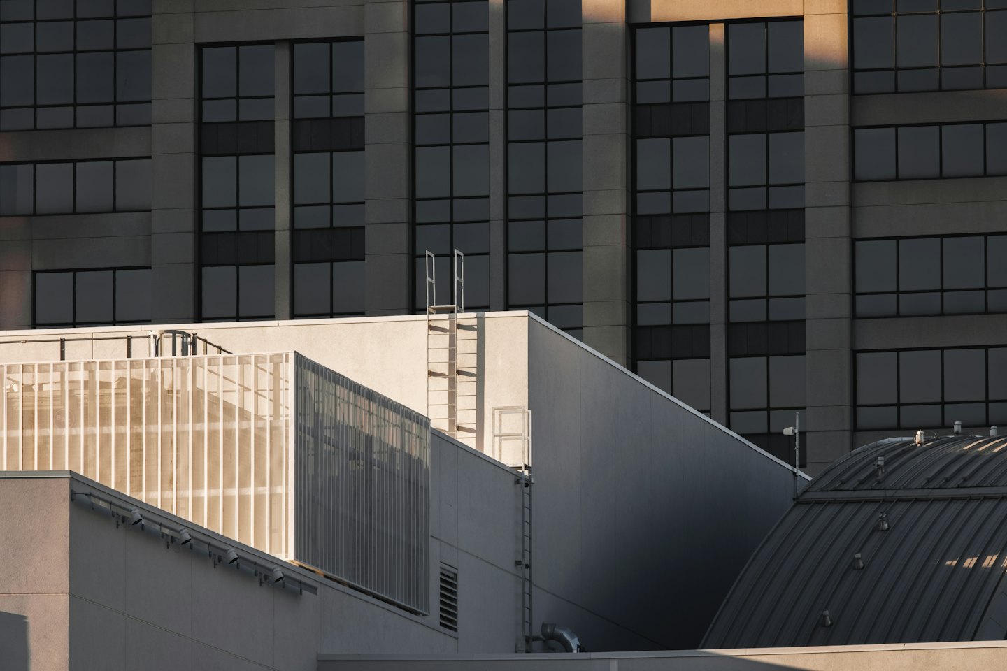 Modern concrete buildings with dark windows and metal railings.